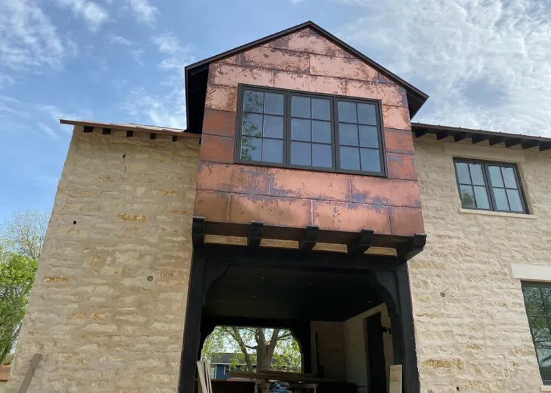 Copper metal panel facade on a stone building for Roof Repair in Bay City